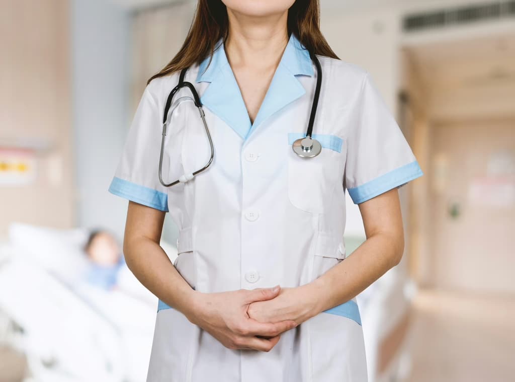 Clinician in uniform with a stethoscope in a clinic hallway