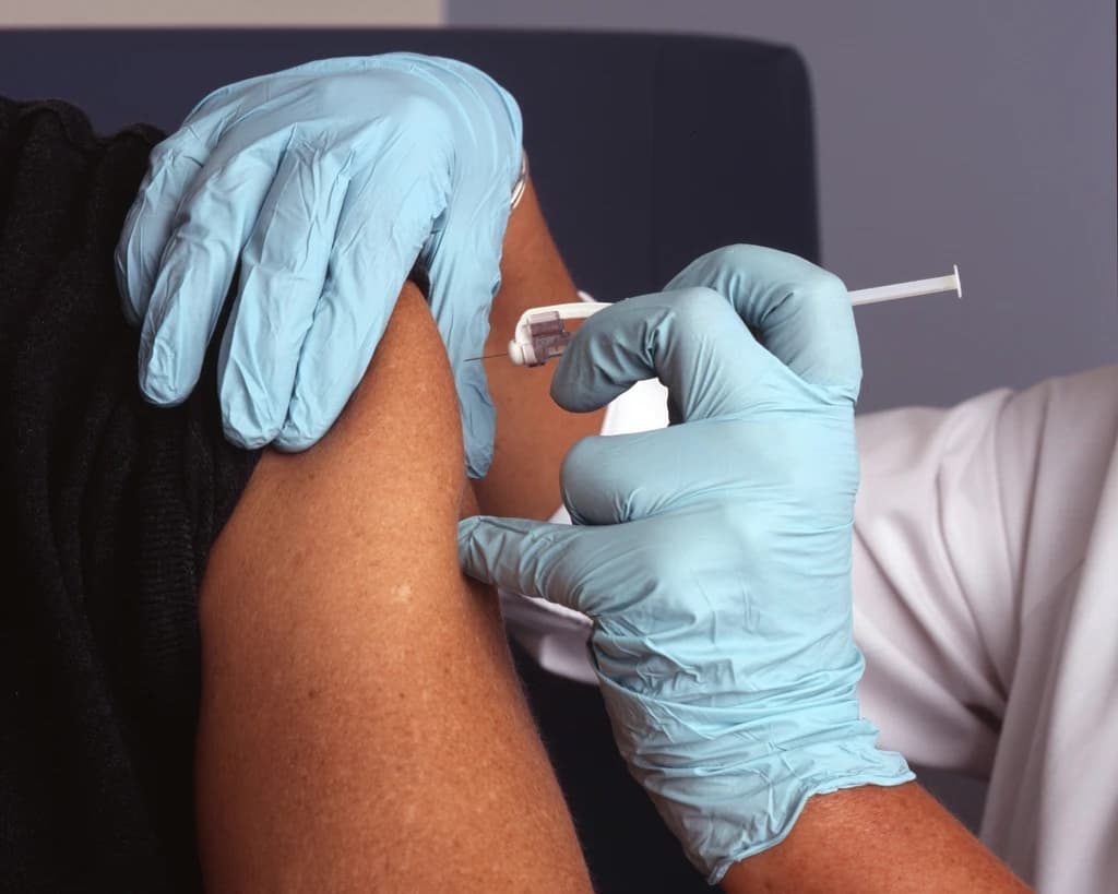 Primer plano de una vacuna aplicándose en el brazo
